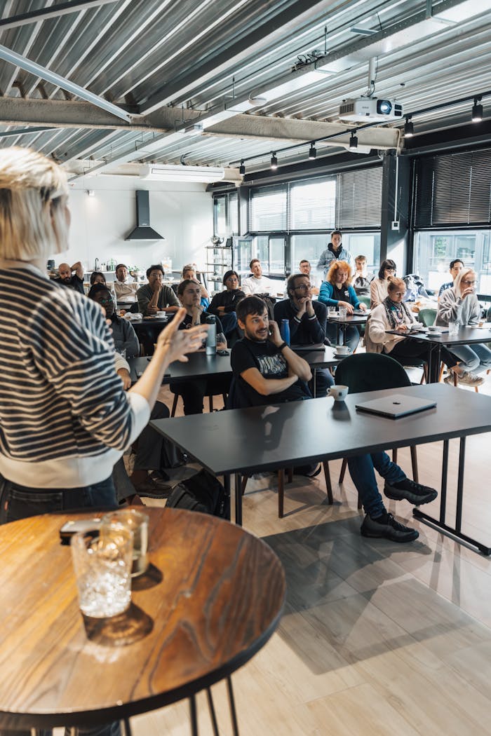 A presenter engages an attentive audience during a business workshop indoors.