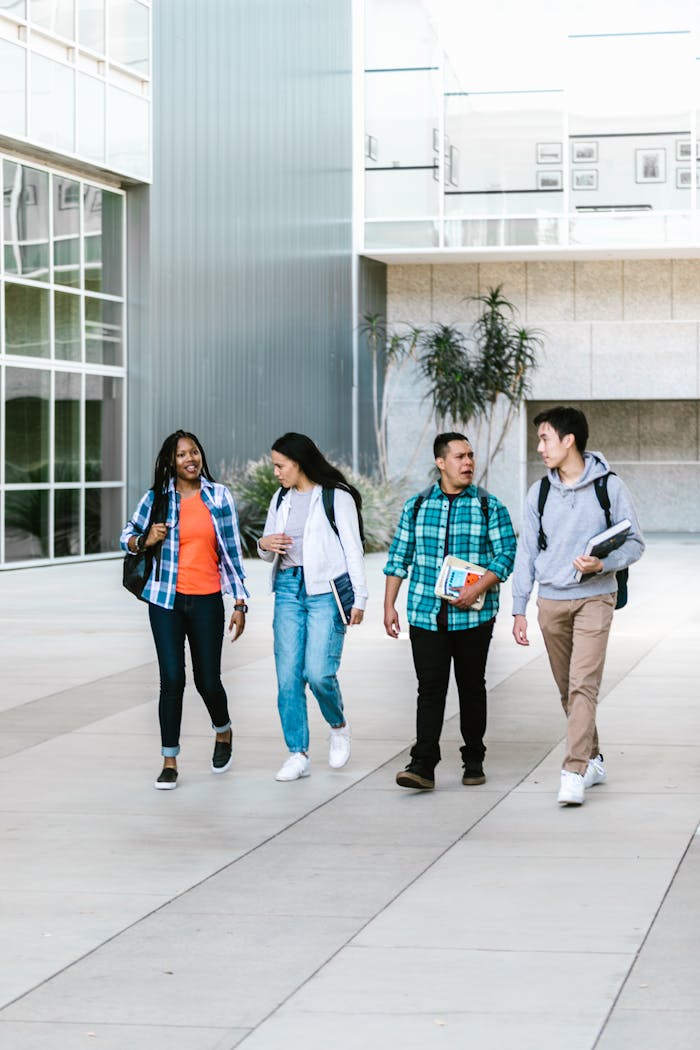 Group of diverse college students walking together on campus. Friendship and education concept.